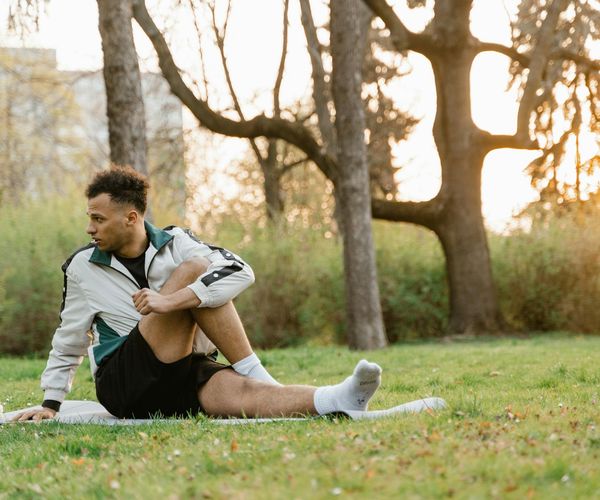 Person stretching outdoors at sunrise, symbolizing vitality and energy.